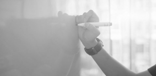 person-drawing-on-whiteboard-770